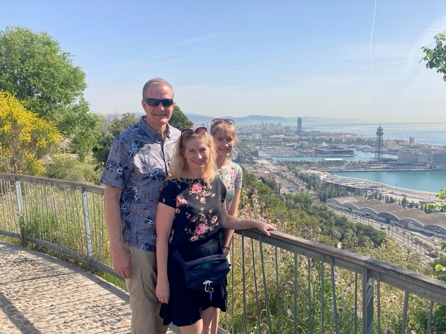 Couple posing with a panoramic view of a seaside city.