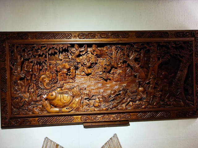 Ornate wooden carving depicting a Balinese scene.