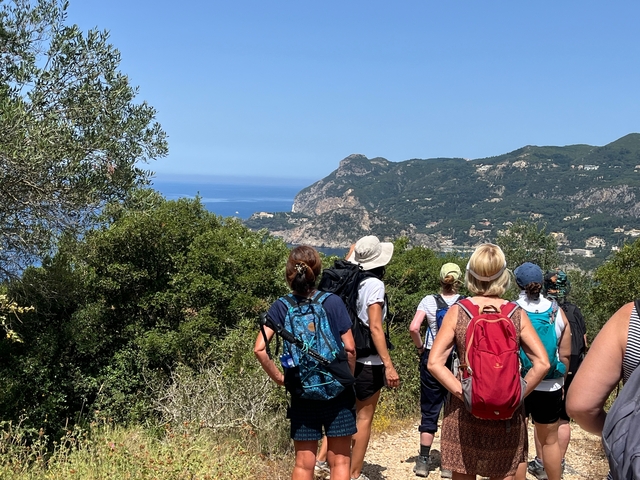 Group of people hiking with a scenic mountain view.