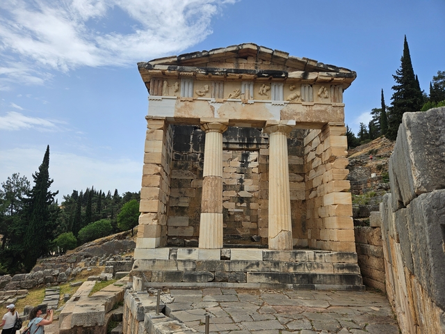       Ancient Greek temple structure with pillars and stone walls.
  