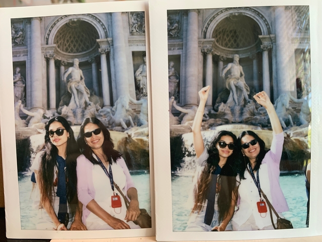 Two women posing in front of the Trevi Fountain.