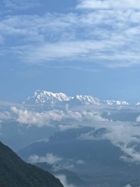 Distant snow-capped mountains with fluffy clouds.