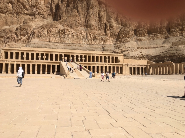       Tourists visiting an ancient temple with multiple statues.
  