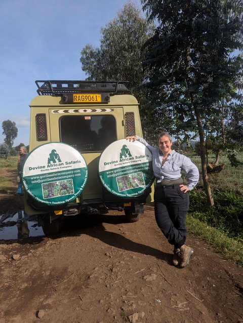      Woman standing by a safari vehicle with branded tire covers.
  