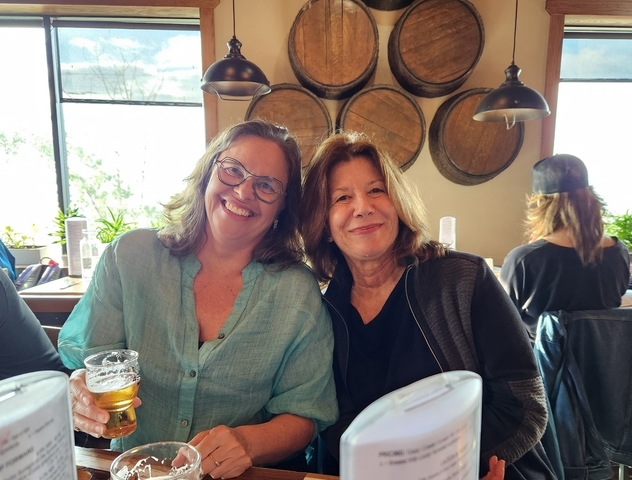 Indoor shot of two women in a casual setting with drinks.