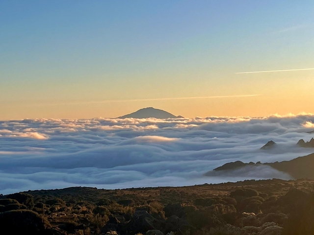 Clouds over a distant mountain seen from a high altitude.
