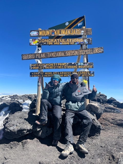Two hikers at Uhuru Peak, Tanzania's highest point.