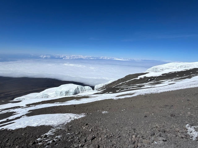       Snow-draped mountain with an expansive view of the clouds.
  