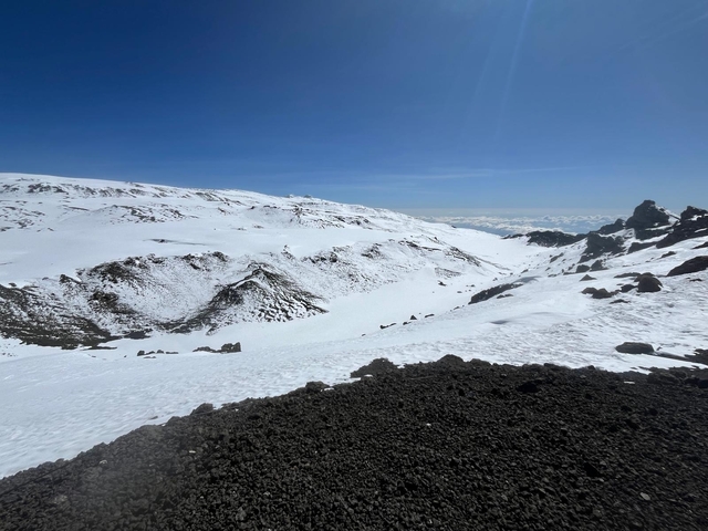       Snow-covered landscape with rugged terrain and bright sunlight.
  