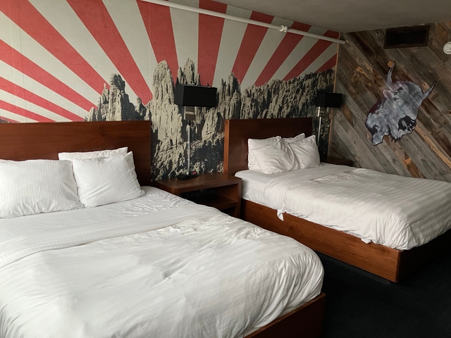 Interior of a hotel room with two beds and modern decor.