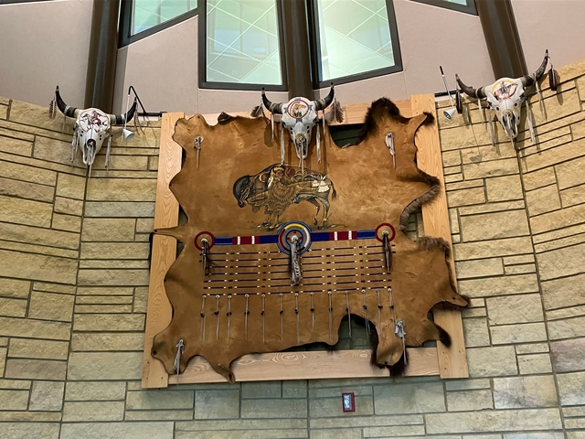 Interior decor with animal skulls and traditional artwork on a wall.