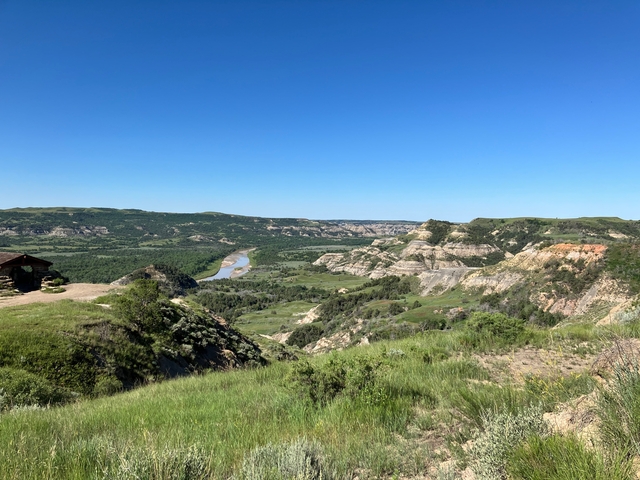 Scenic view of a river valley and bluffs with clear blue sky.