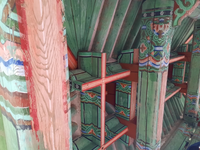       Close-up of colorful wooden beams and ornamentation of a traditional building.
  