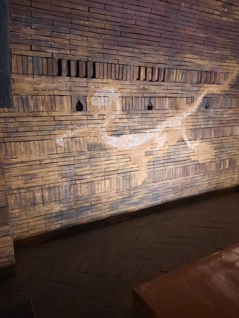       Ancient inscribed clay bricks arranged in a wall display.
  