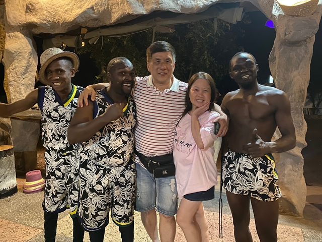       Group of people posing with local performers.
  