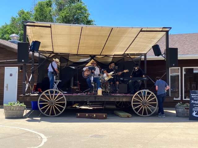 A band performing on a wagon stage outdoors.