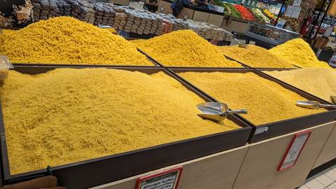 Piles of yellow spices on display in a market.