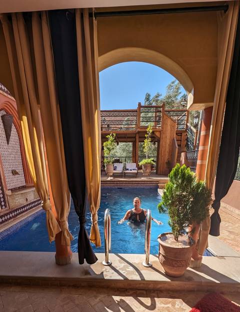       Person in a swimming pool surrounded by luxurious decor.
  