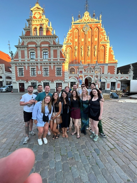 Group posing in front of historical building.