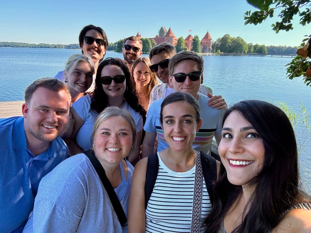 Group selfie with a castle and lake in the background.