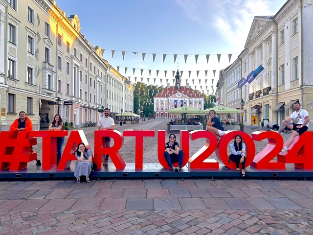 Group posing with Tartu 2024 sign in the background.