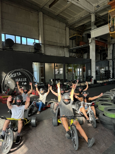 Group posing with helmets in a go-kart setting.