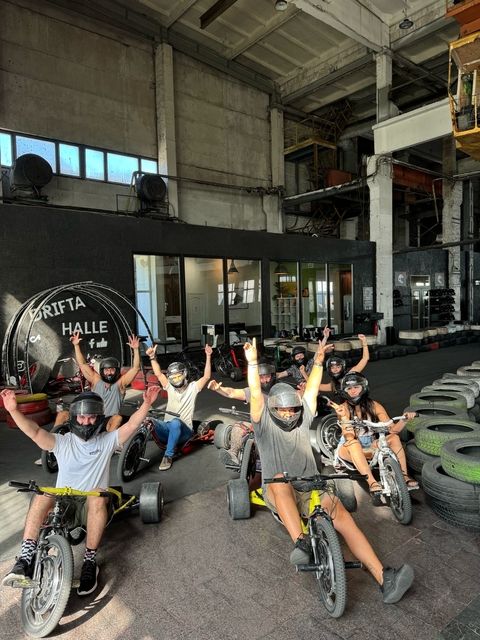 Group of people wearing helmets, seated on drift trikes.