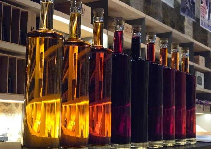 Bottles of variously colored liquids on display.