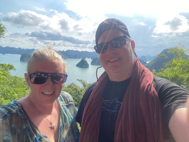 Two people taking a selfie with water and small islands in the background.