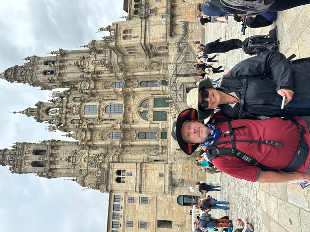 Two people posing in front of the Santiago de Compostela Cathedral.