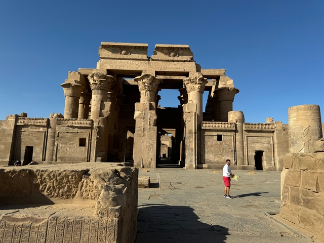       A person standing in front of the Kom Ombo Temple.
  