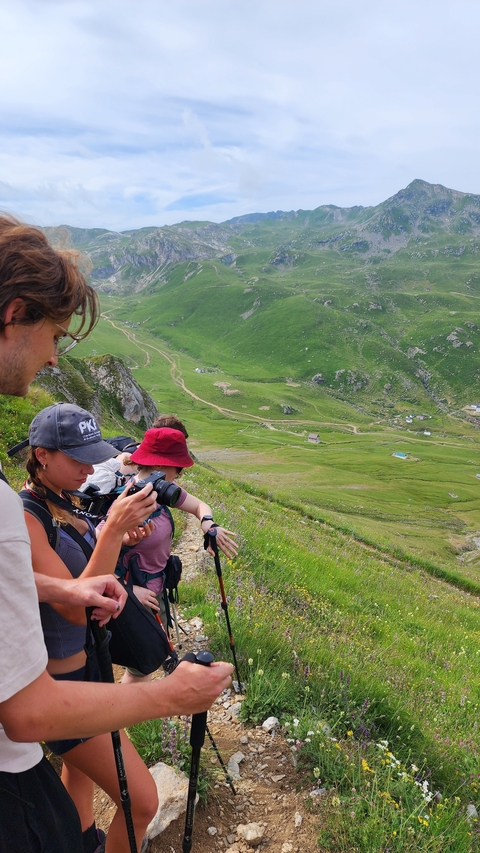 Group of hikers enjoying a mountainous landscape with green valleys.