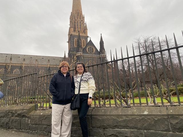 Two people posing in front of an iconic church.