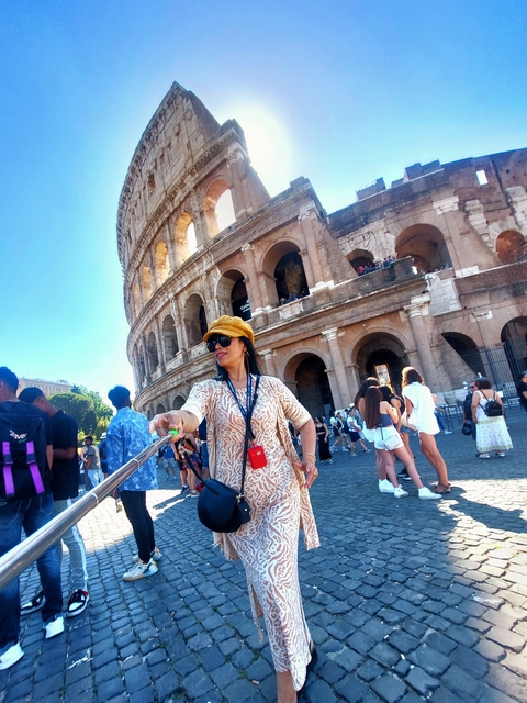 People taking a selfie in front of the Colosseum in Rome, Italy.