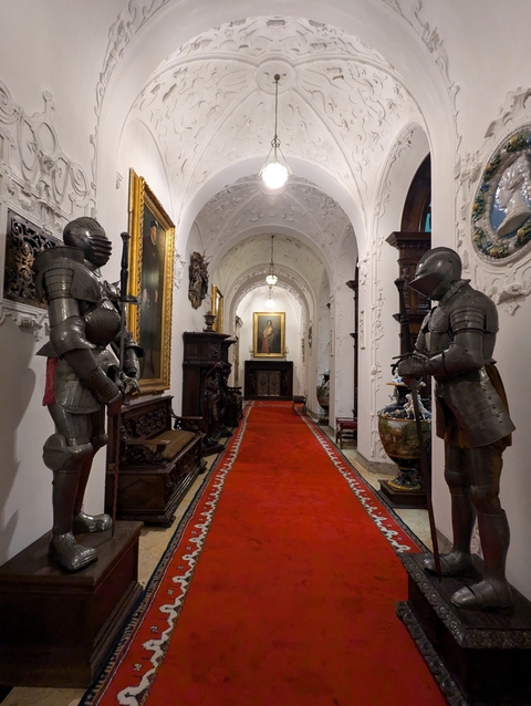       Hallway with medieval armor displays.
  