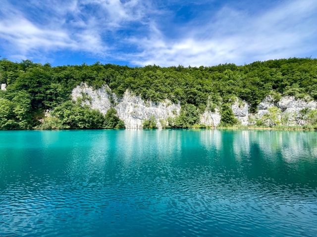       Calm azure lake with rocky cliffs.
  