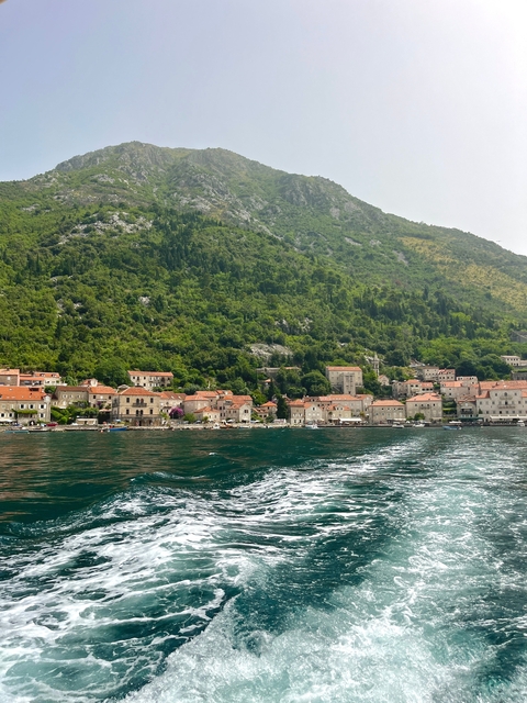       Coastal town with buildings and mountains.
  
