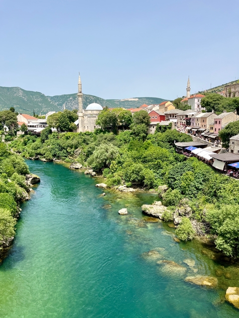       Colorful town with river and green surroundings.
  
