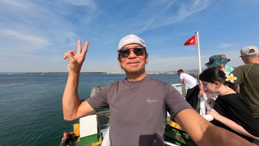       Person taking a selfie on a boat, with calm ocean in the background.
  