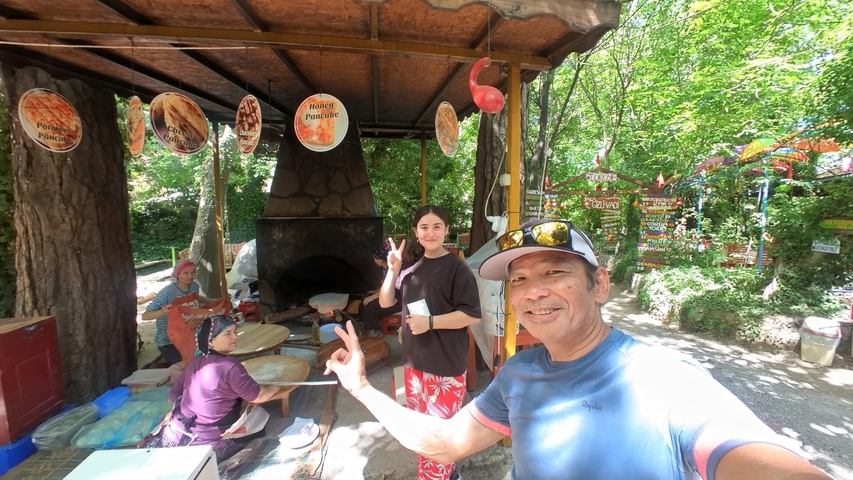 Group of people making traditional cuisine outside with a wood-fired oven.