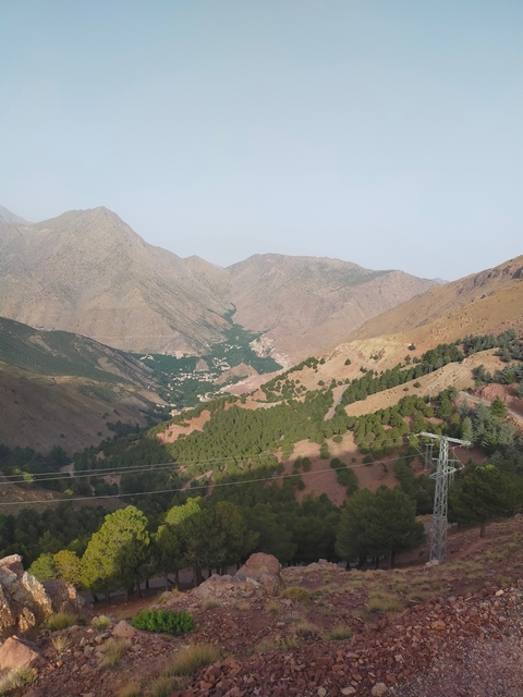       Mountainous landscape with a valley and scattered settlements.
  