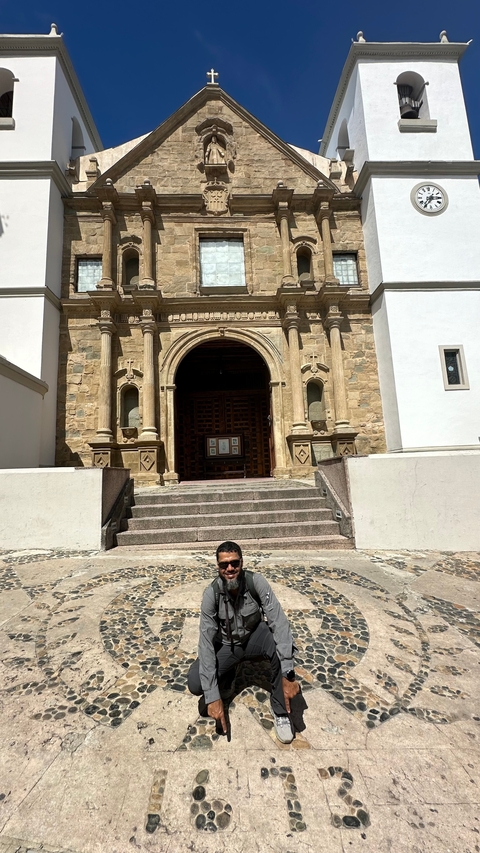       Person in front of an ancient building with decorative stone carvings.
  