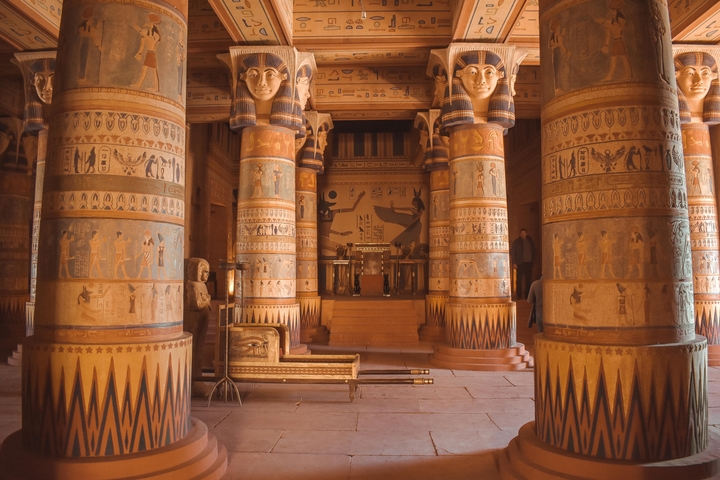 Interior of an ancient temple with ornate columns and hieroglyphs.