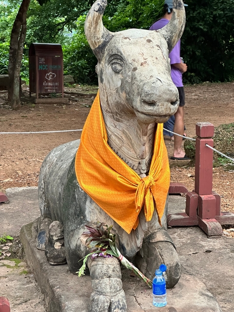 Stone sculpture covered with an orange cloth.