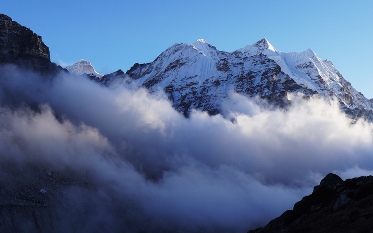       Snowy mountain peaks above the clouds.
  