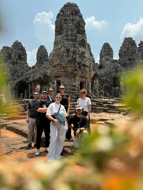 Small group in front of a detailed temple ruin.