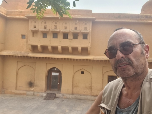 Man taking a selfie in front of a historic building.