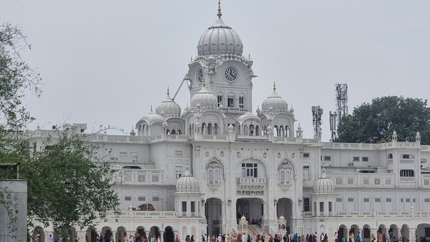       A white domed temple with intricate designs.
  