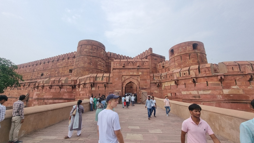       The entrance of a large fort with many tourists.
  