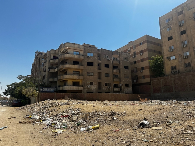 Apartment buildings with a pile of garbage in the foreground.
